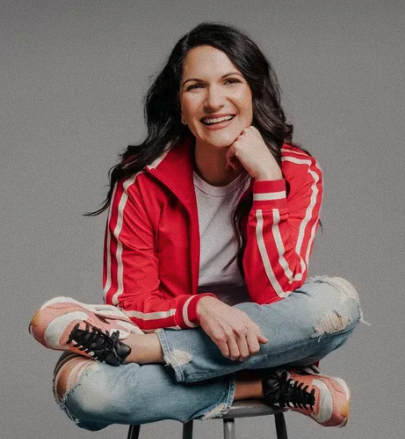 Image of Amy sitting on a stool smiling
