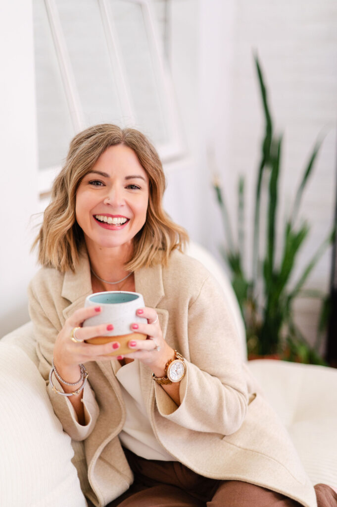 Amanda sitting on a couch holding a coffee mug